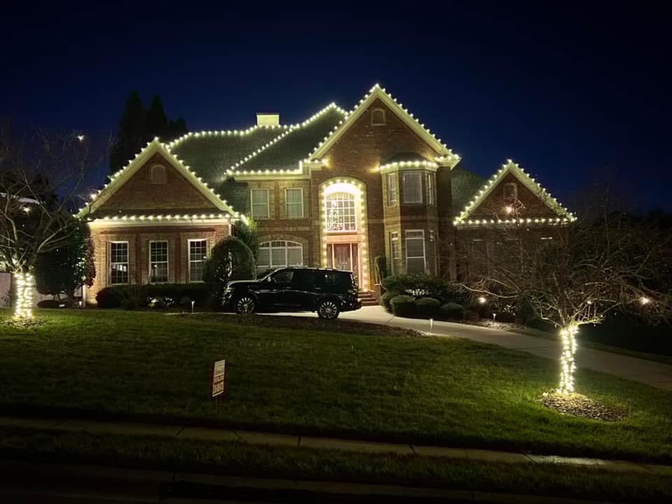 Large brick home with roofline lights and wrapped front yard trees